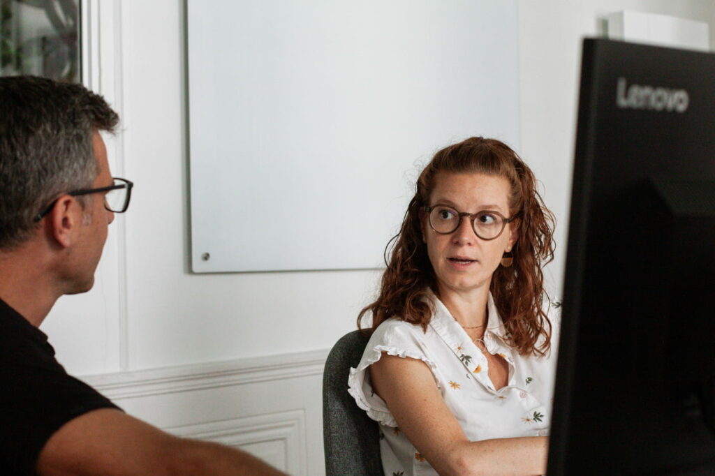 Deux consultants, une femme et un homme, qui échangent sur le sujet flux tiré (DDMRP)